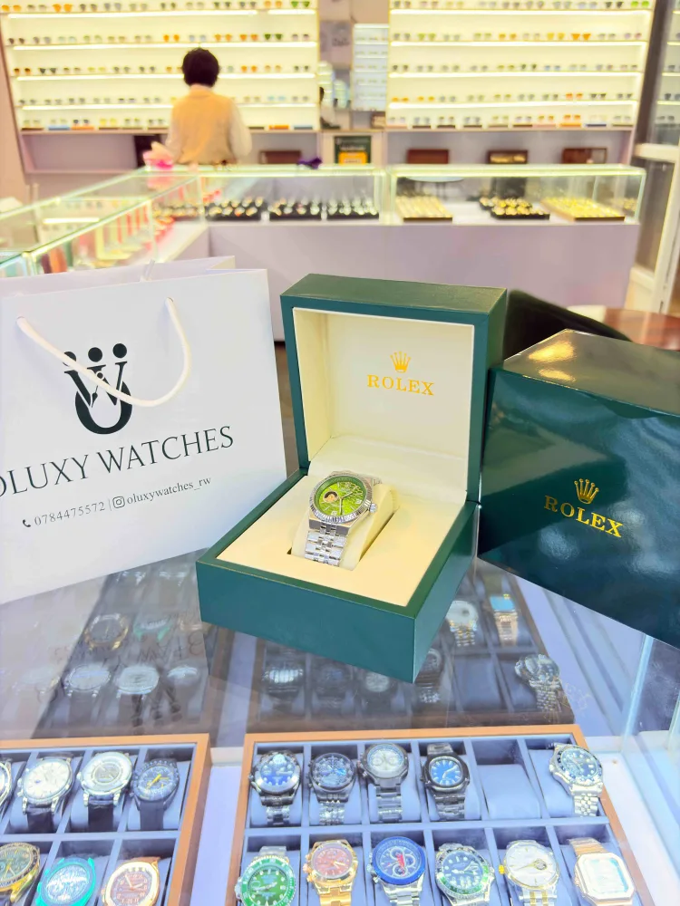 A watch in its green box beside the white Oluxy Watches bag, on the shop counter