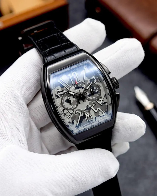 A black Franck Muller held in white gloves